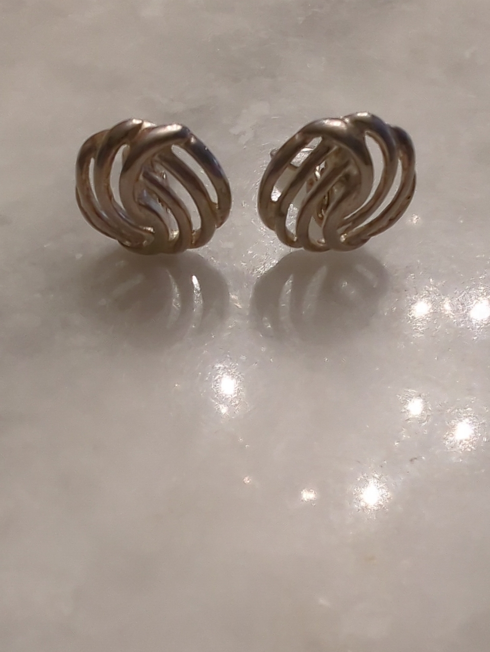 vintage Monet Silver-tone swirl knot earrings from around the 1980s